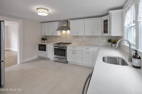 a kitchen with stainless steel appliances granite countertop a refrigerator and a stove top oven