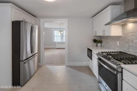 a large white kitchen with a stove top oven a sink and dishwasher