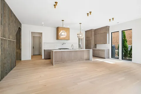 a kitchen with stainless steel appliances granite countertop a sink a stove and a wooden floors