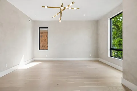 an empty room with windows and mirror