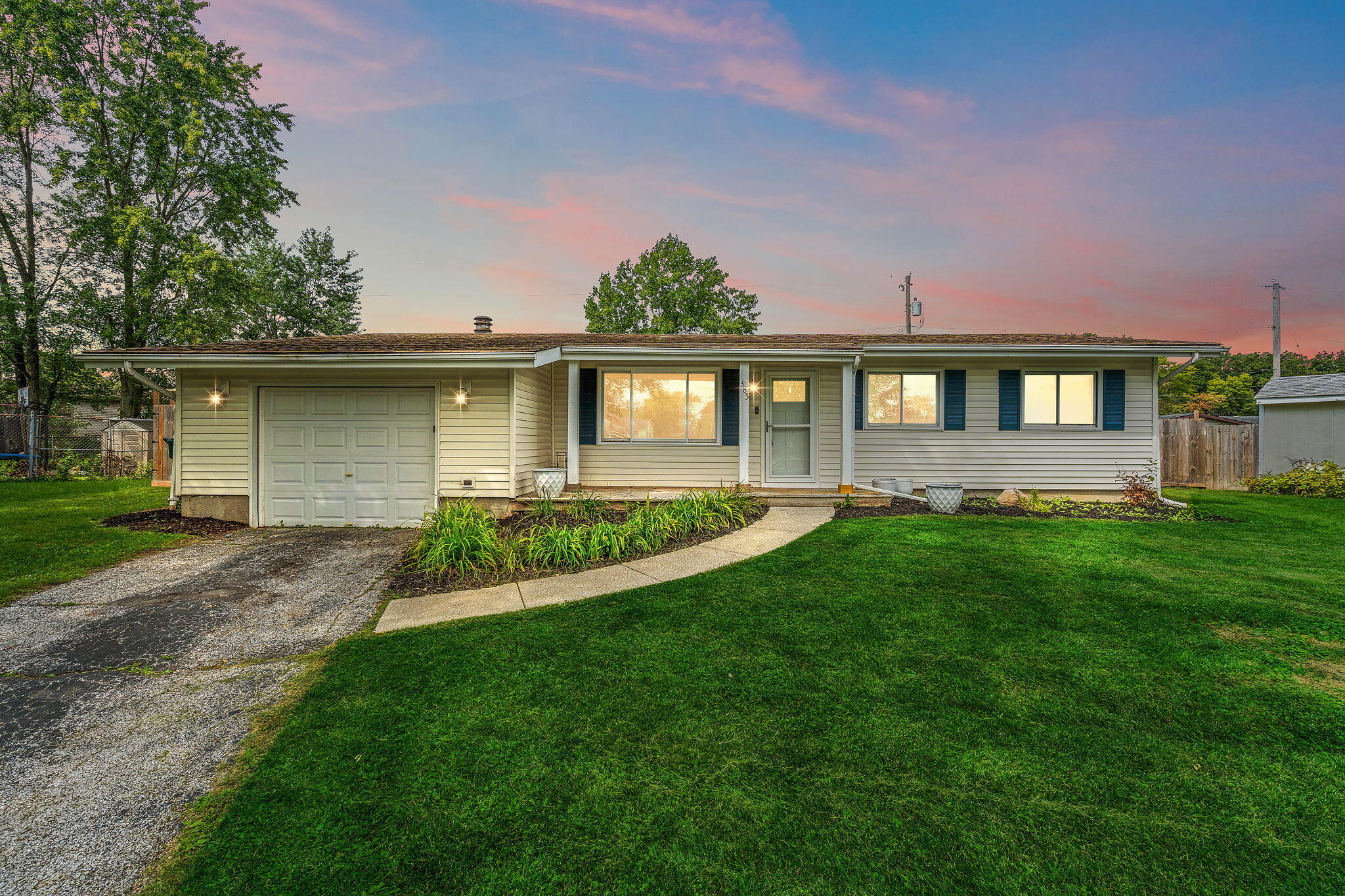 a front view of a house with a yard and potted plants
