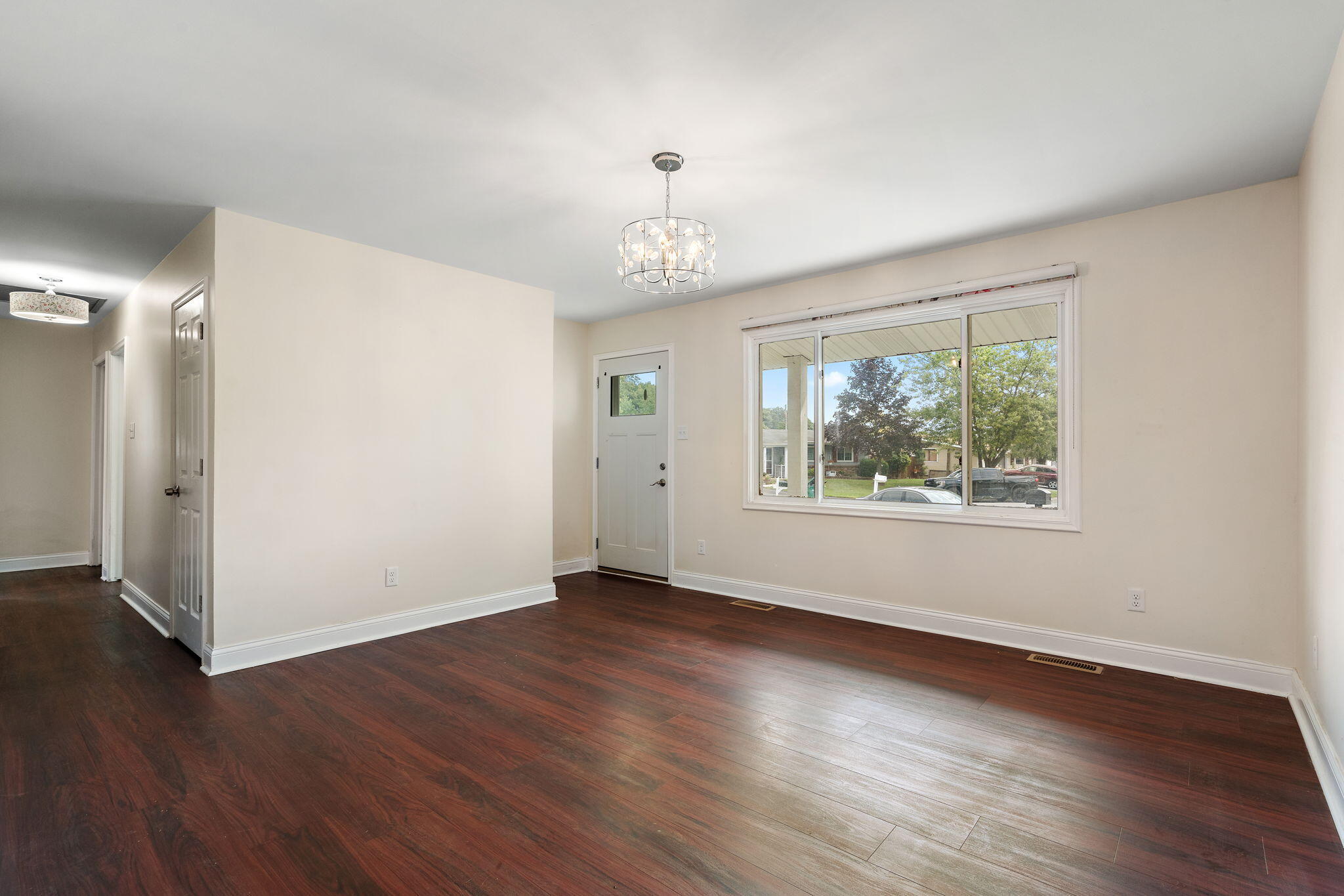 385 Riviera Court Valparaiso, IN 46385 - Photo 5 of 27 an empty room with wooden floor chandelier and windows