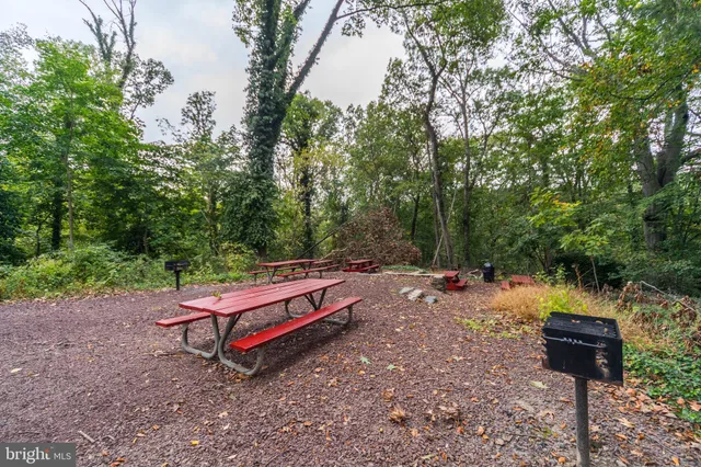 a backyard of a house with barbeque oven table and chairs