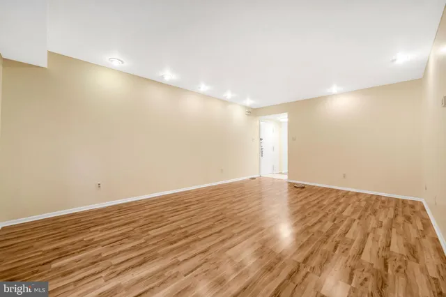 a view of an empty room with wooden floor