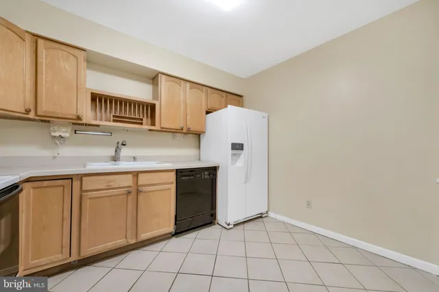 a kitchen with a sink a refrigerator and cabinets