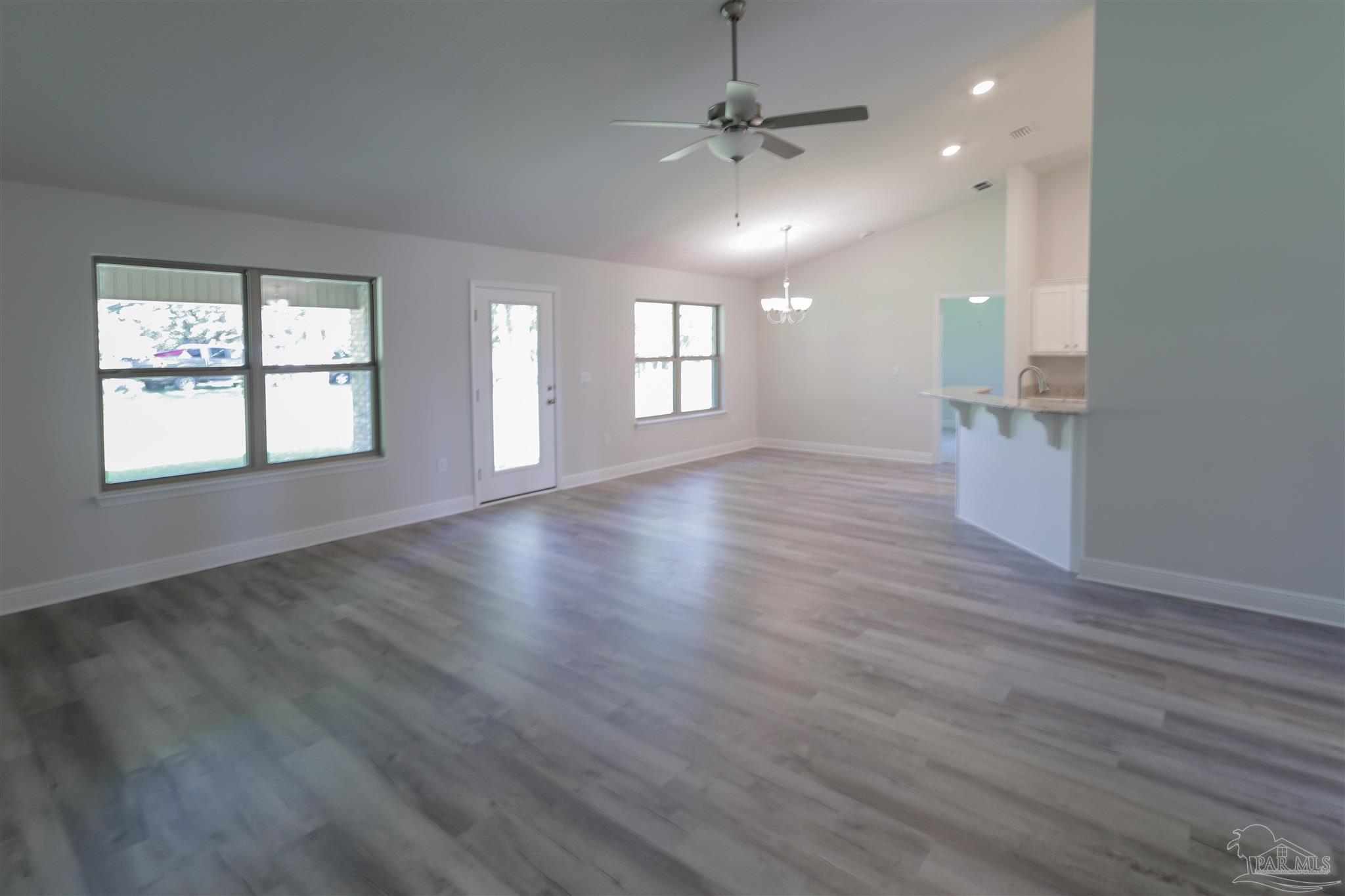 5979 Parsonage Circle Milton, FL 32570 - Photo 11 of 26 an empty room with wooden floor and windows