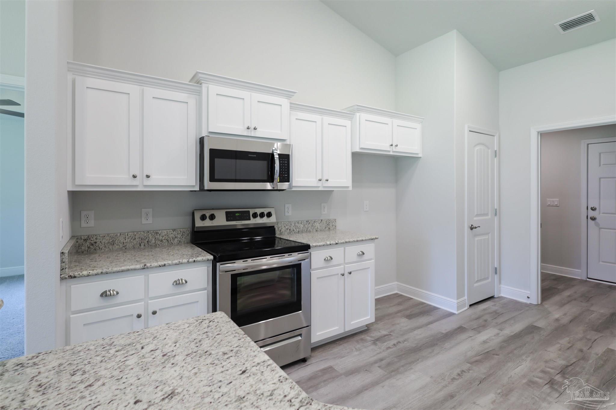 5979 Parsonage Circle Milton, FL 32570 - Photo 14 of 26 a kitchen with stainless steel appliances granite countertop a stove a sink and a microwave