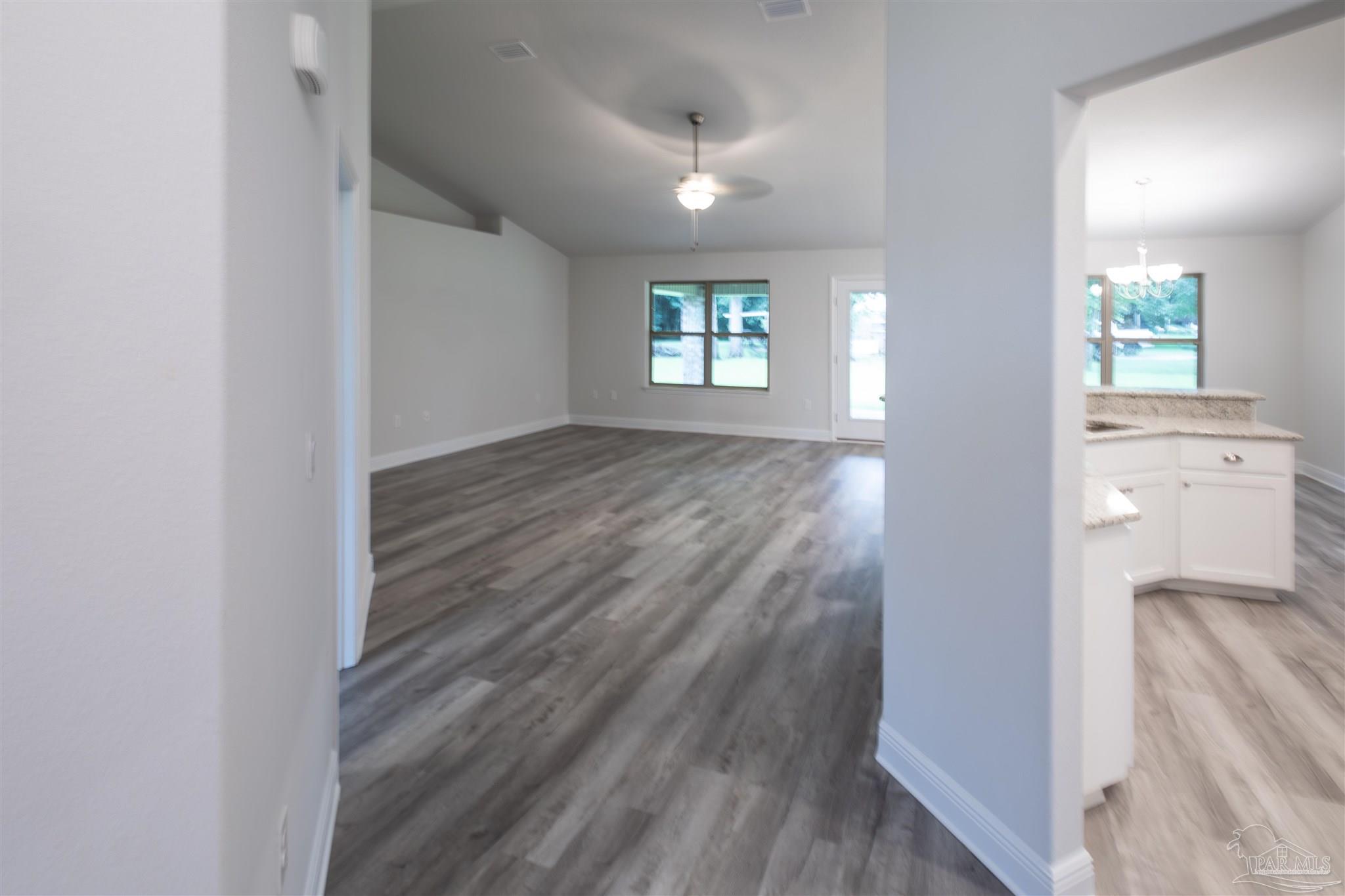5979 Parsonage Circle Milton, FL 32570 - Photo 8 of 26 a view of a hallway with wooden floor and a bathroom