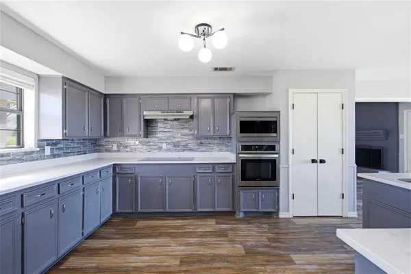 a kitchen with stainless steel appliances granite countertop a refrigerator and a stove top oven