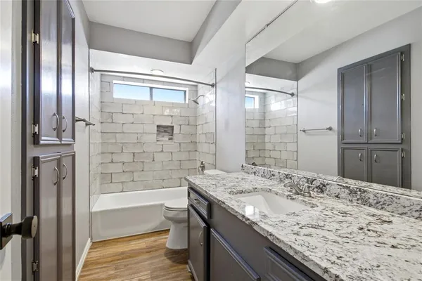 a bathroom with a granite countertop sink toilet and shower