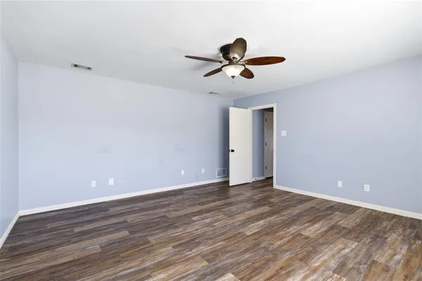 a view of room with wooden floor and ceiling fan