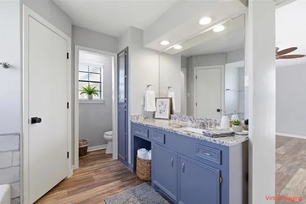 a bathroom with a granite countertop sink mirror and toilet