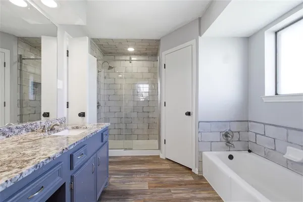 a bathroom with a bathtub shower sink double and mirror