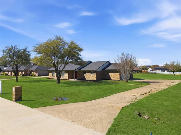 a front view of a house with yard and green space