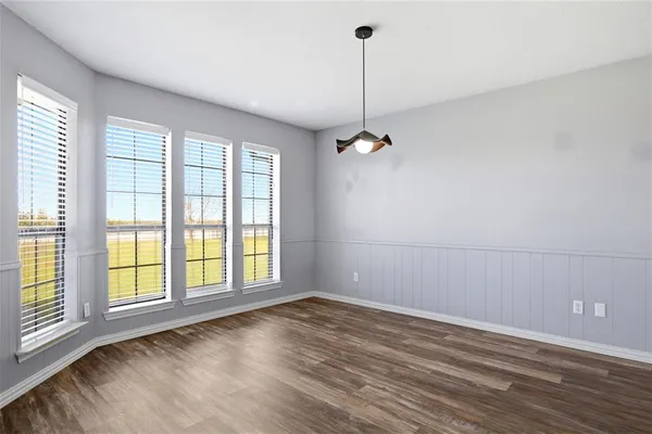 a view of an empty room with window and chandelier fan