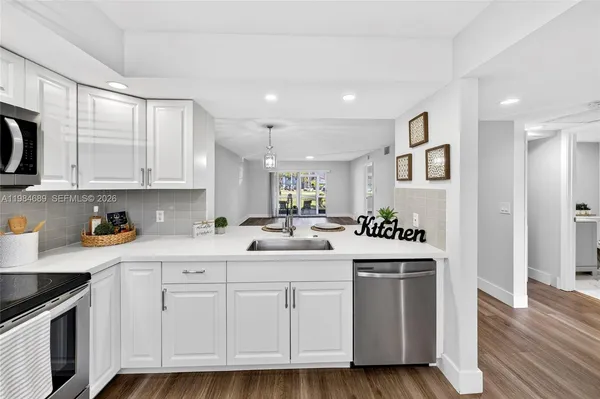 a kitchen with white cabinets and sink