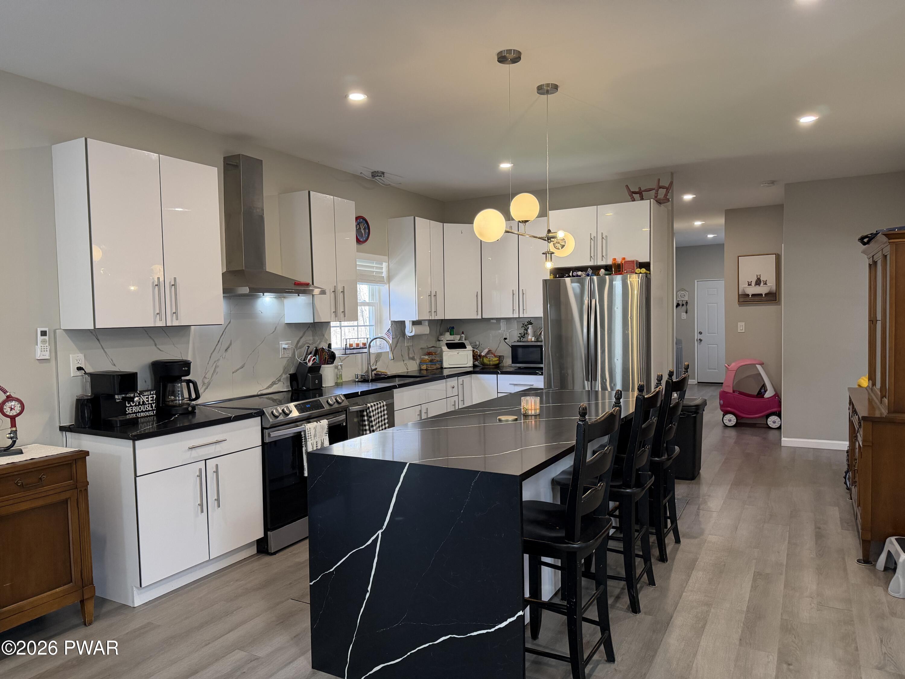 801 Maple Ridge Court Hawley, PA 18428 - Photo 14 of 55 a kitchen with stainless steel appliances granite countertop a table chairs sink refrigerator and cabinets