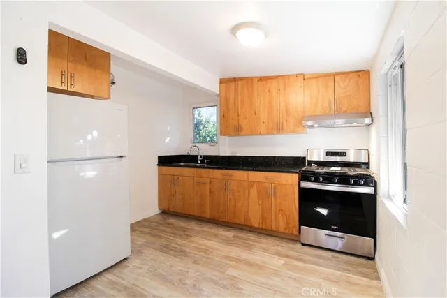 a kitchen with stainless steel appliances granite countertop a stove a sink and a refrigerator