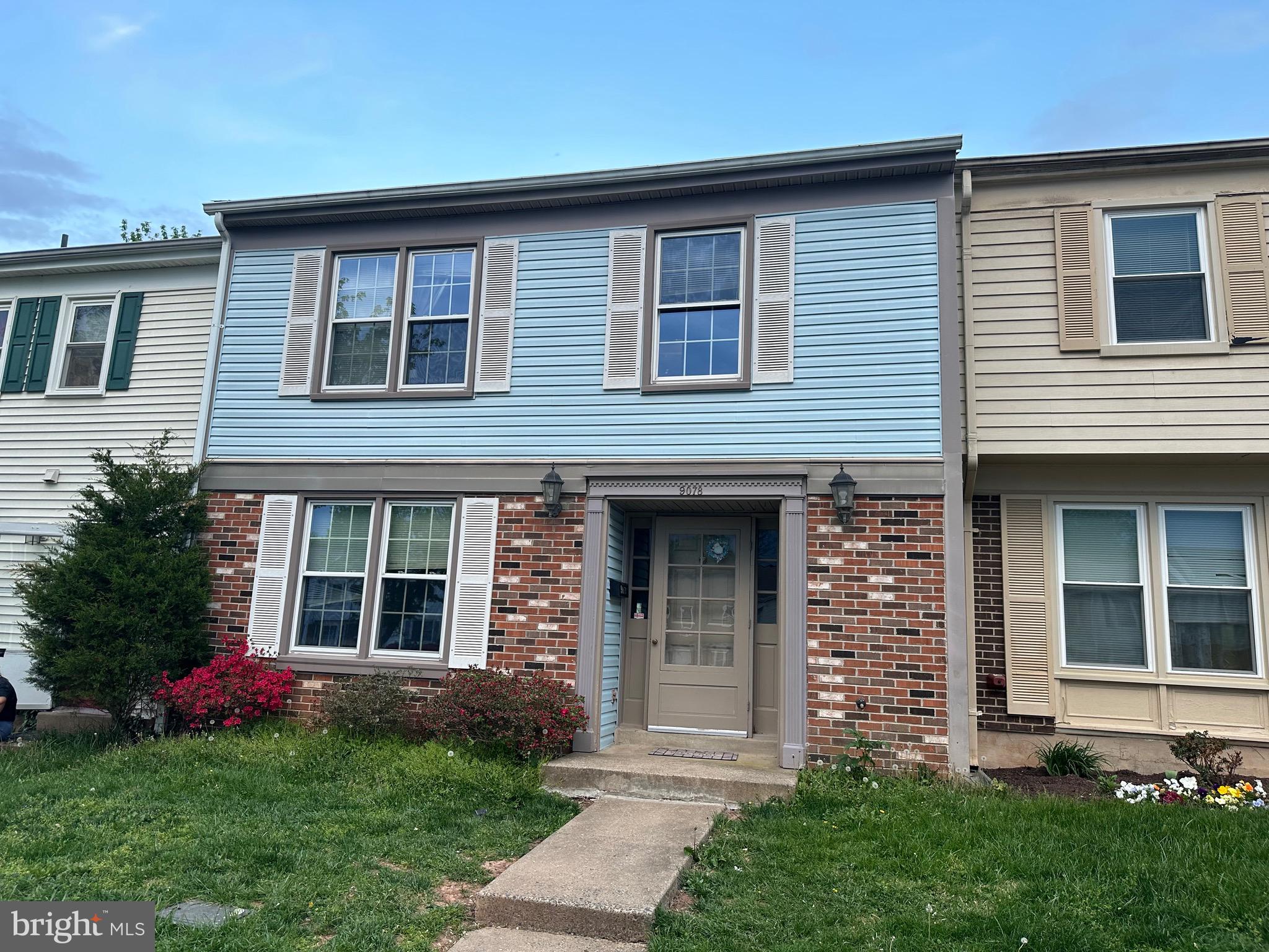 a brick house that has a lots of windows in it