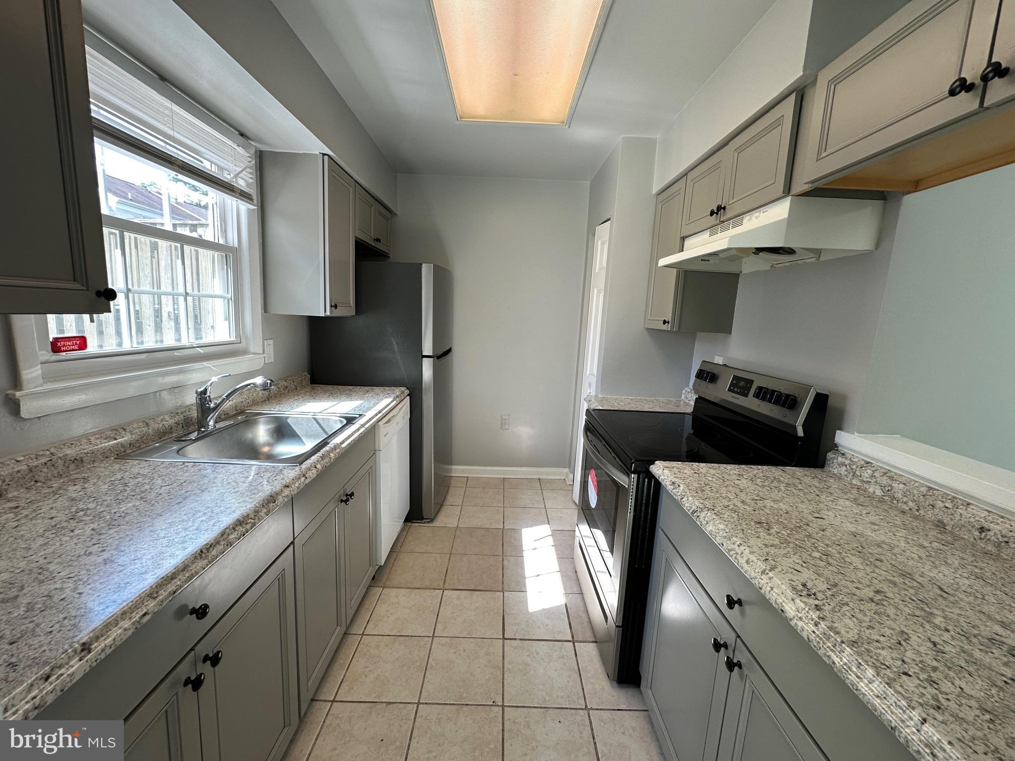 9078 McClellan Common Manassas, VA 20110 - Photo 7 of 25 a kitchen with granite countertop a sink stove and cabinets