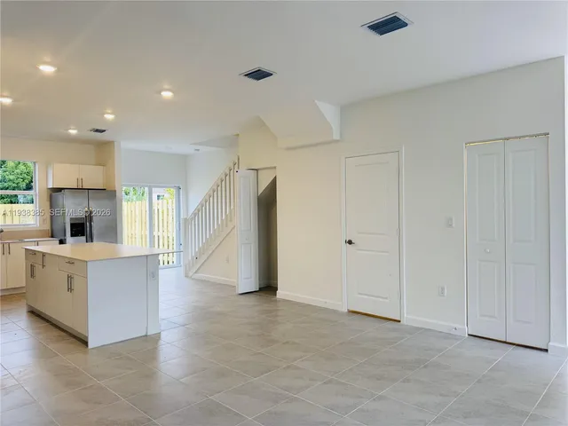 a view of kitchen with sink electronic appliances and window