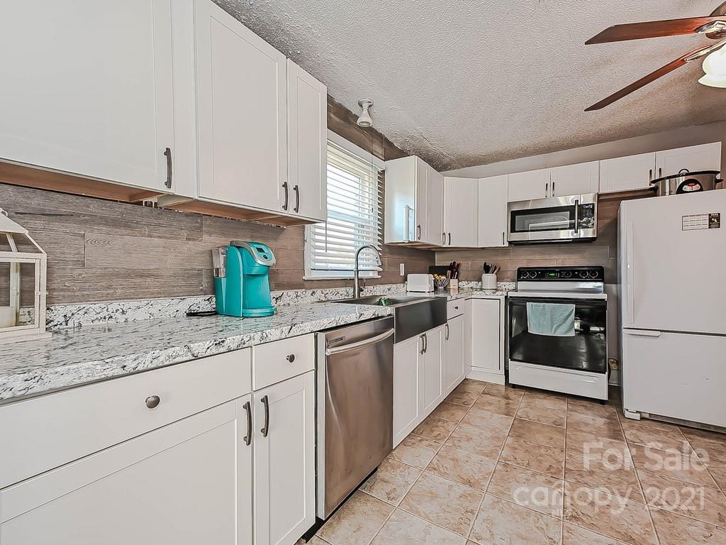 408 West Sandy Ridge Road Monroe, NC 28112 - Photo 5 of 21 a kitchen with granite countertop a sink stainless steel appliances and white cabinets