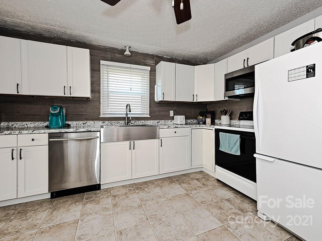 408 West Sandy Ridge Road Monroe, NC 28112 - Photo 8 of 21 a kitchen with white cabinets and white appliances