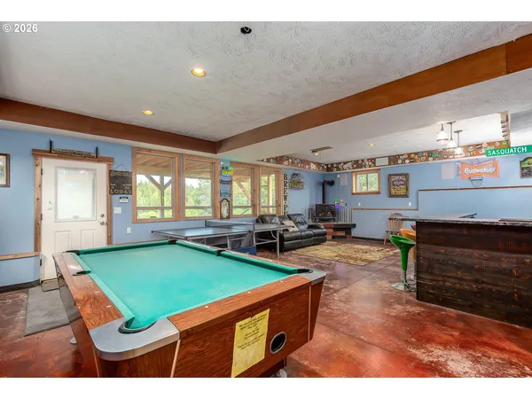 a room with furniture pool table chairs and windows