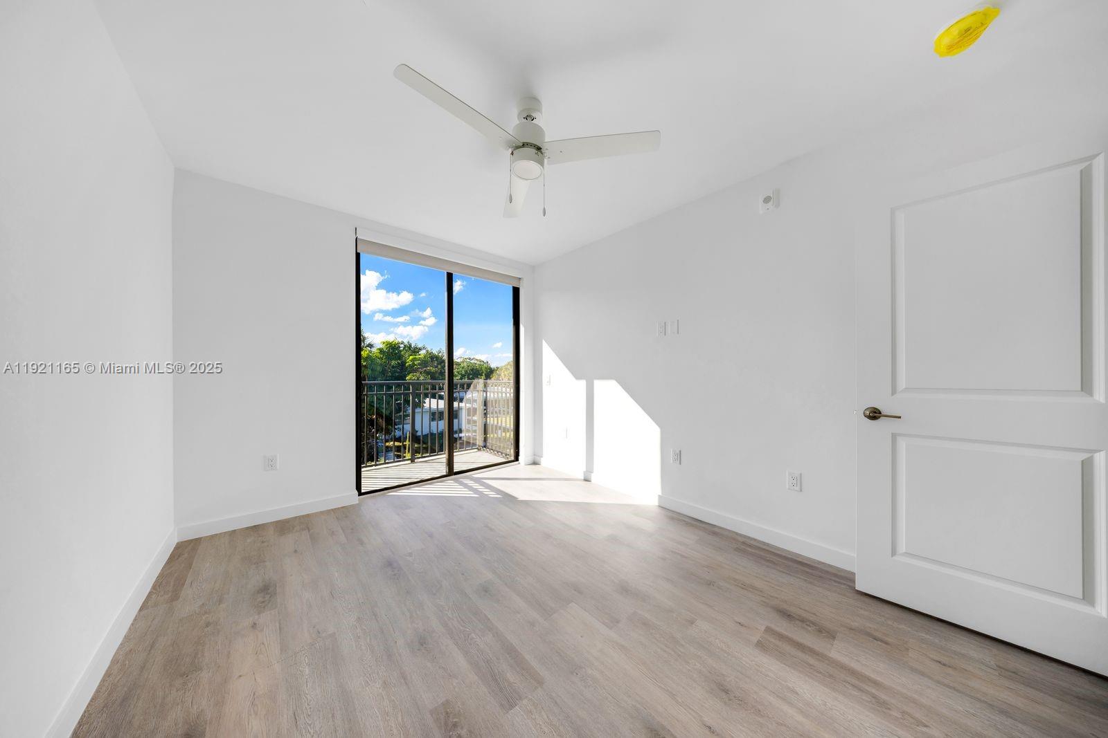 20 Northeast 19th Avenue, Unit 201 Pompano Beach, FL 33060 - Photo 11 of 25 an empty room with wooden floor and windows