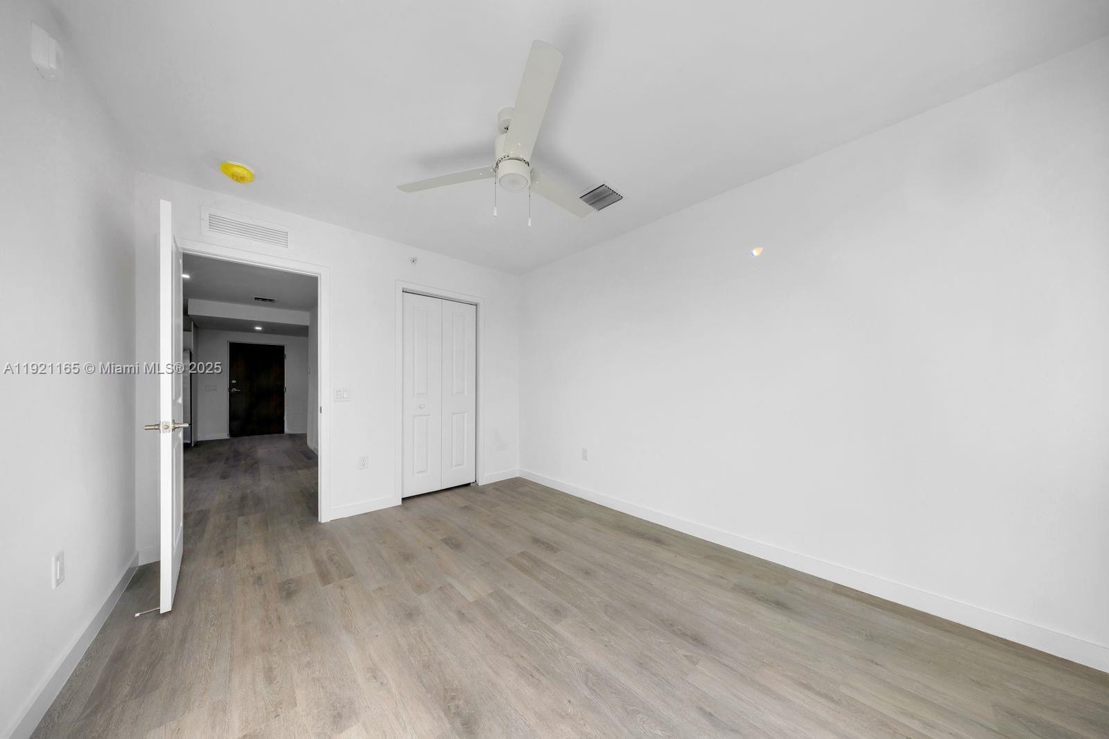 20 Northeast 19th Avenue, Unit 201 Pompano Beach, FL 33060 - Photo 13 of 25 a view of an empty room with wooden floor and a window