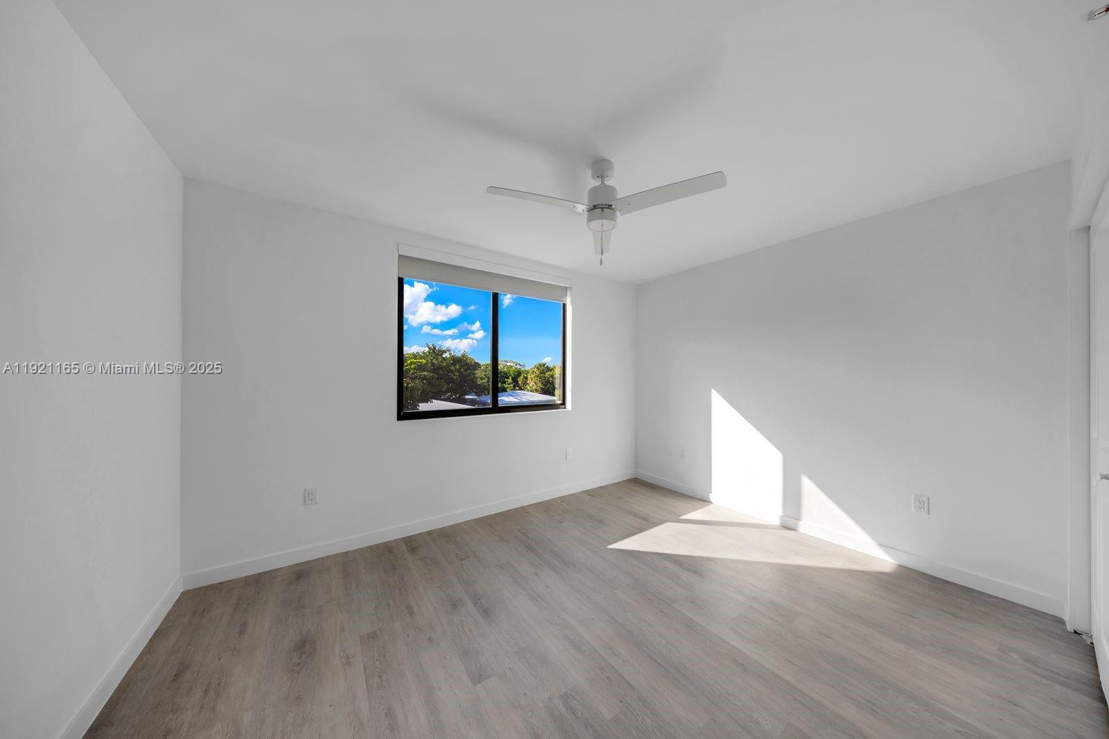 20 Northeast 19th Avenue, Unit 201 Pompano Beach, FL 33060 - Photo 15 of 25 a view of an empty room with wooden floor and a window