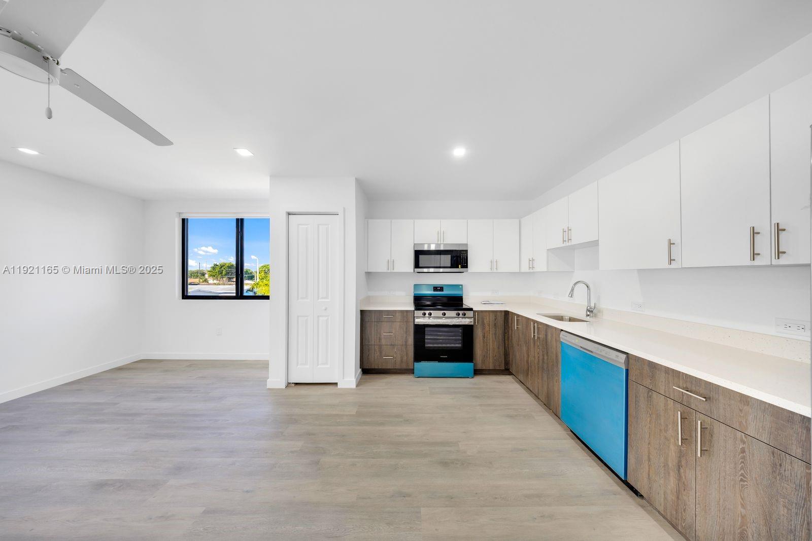 20 Northeast 19th Avenue, Unit 201 Pompano Beach, FL 33060 - Photo 2 of 25 a large kitchen with stainless steel appliances granite countertop a refrigerator and a stove top oven