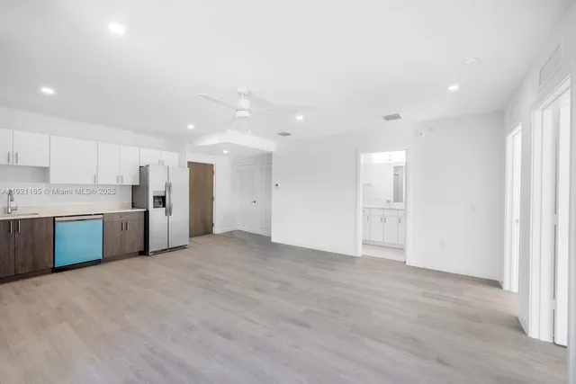 a view of a kitchen with a sink and a refrigerator