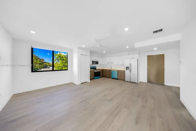 a view of empty room with wooden floor and window