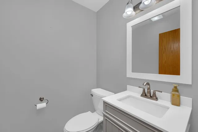 a bathroom with a sink vanity mirror and toilet