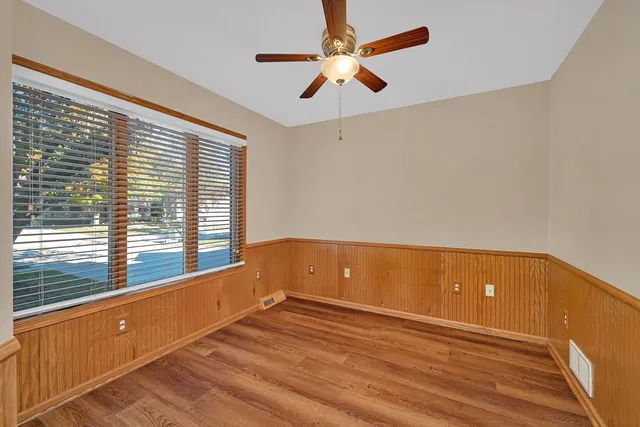 a view of an empty room with a window and a ceiling fan