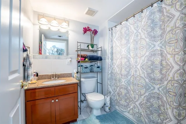 a bathroom with a sink toilet vanity and shower