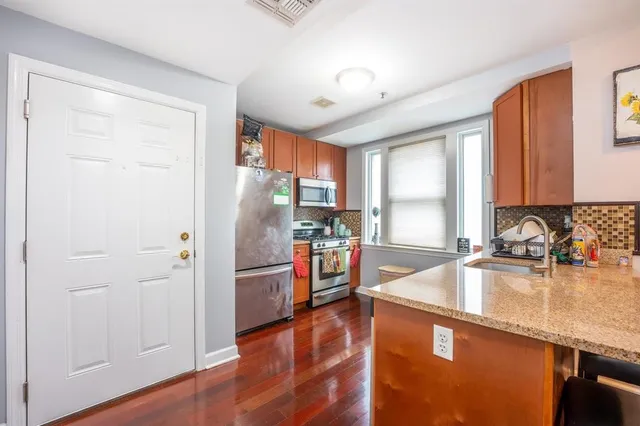 a kitchen with granite countertop a refrigerator and a sink