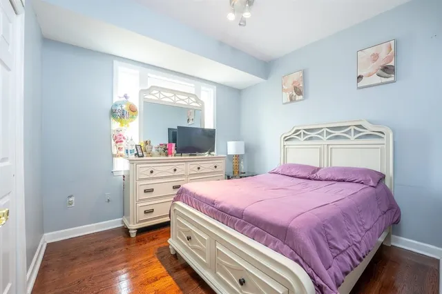 a bedroom with a bed and a flat tv screen on dresser