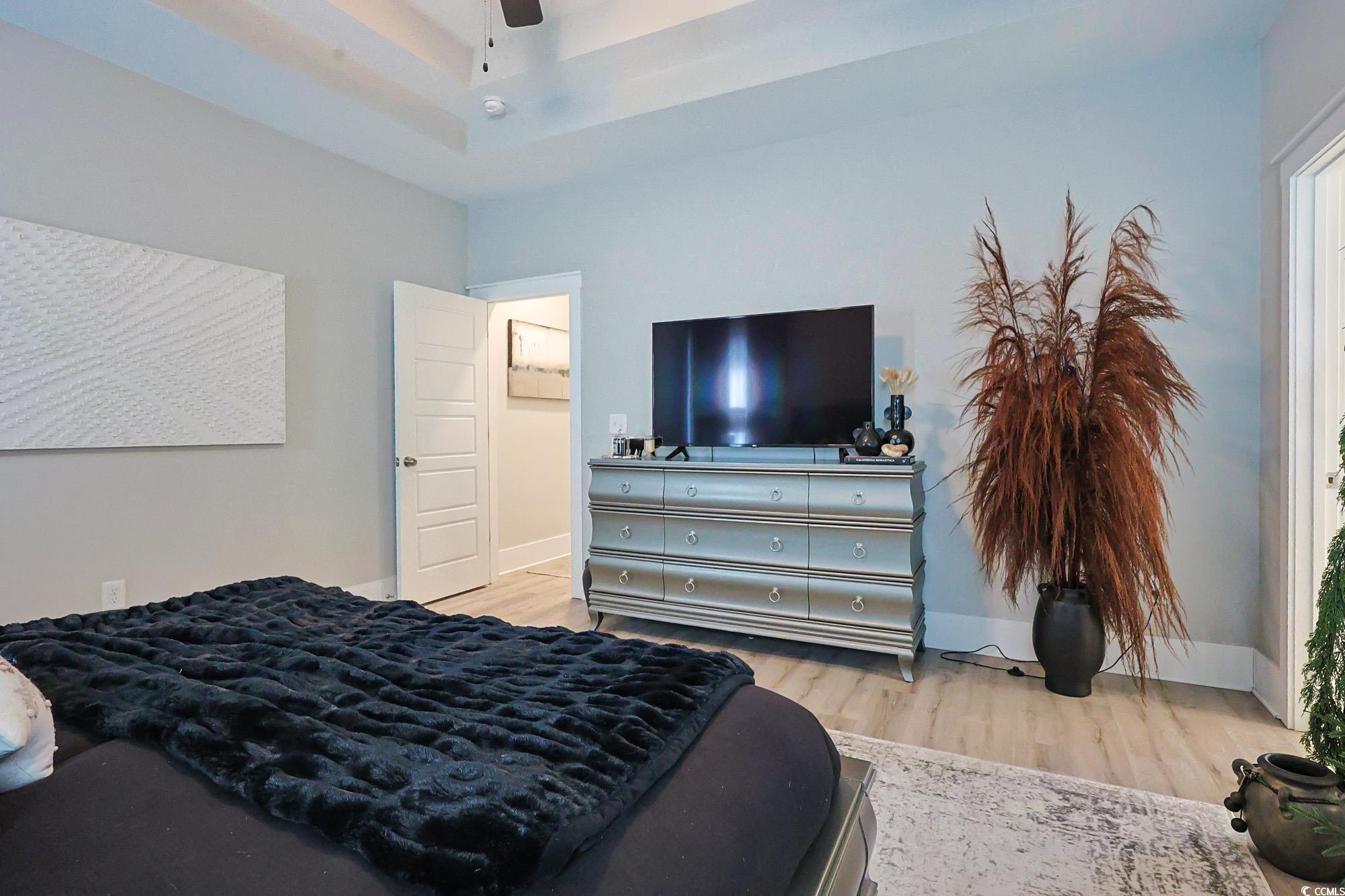 669 Pacific Commons Drive Surfside Beach, SC 29575 - Photo 10 of 36 Bedroom featuring light wood finished floors, a tray ceiling, and ceiling fan
