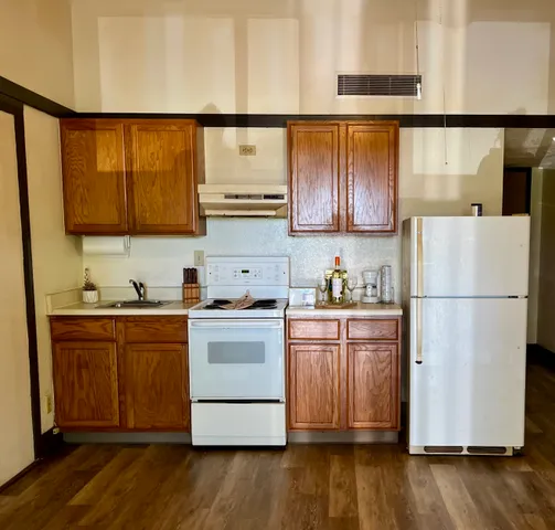 a kitchen with a refrigerator sink and cabinets