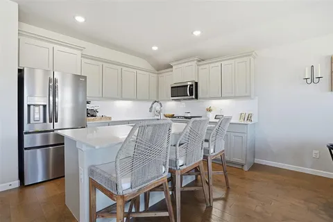 a kitchen with kitchen island a refrigerator stove and microwave