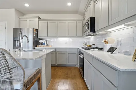 a kitchen with a sink a stove and cabinets