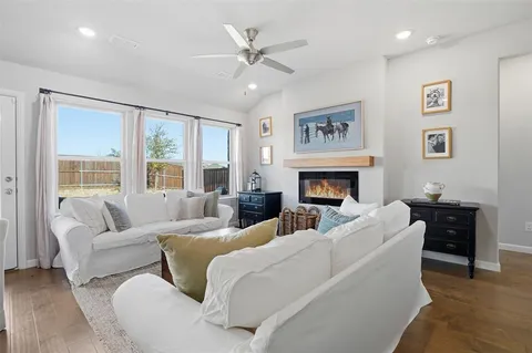 a living room with furniture two windows and a fireplace