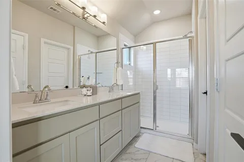 a bathroom with a double vanity sink mirror and shower