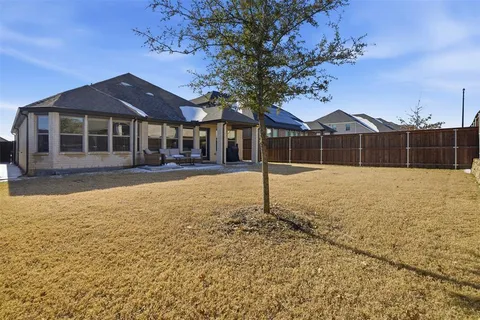 a front view of a house with a yard and tree