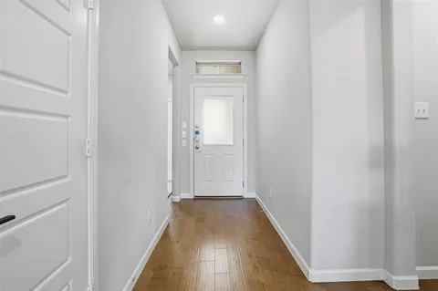 a view of a hallway with wooden floor