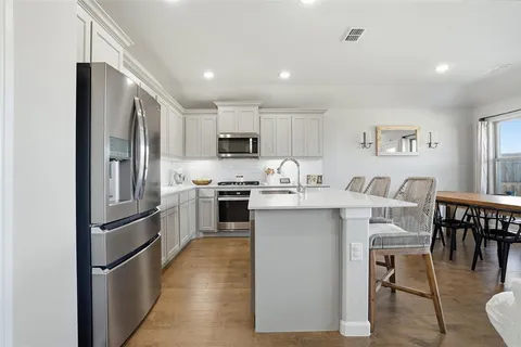 a kitchen with white cabinets and stainless steel appliances