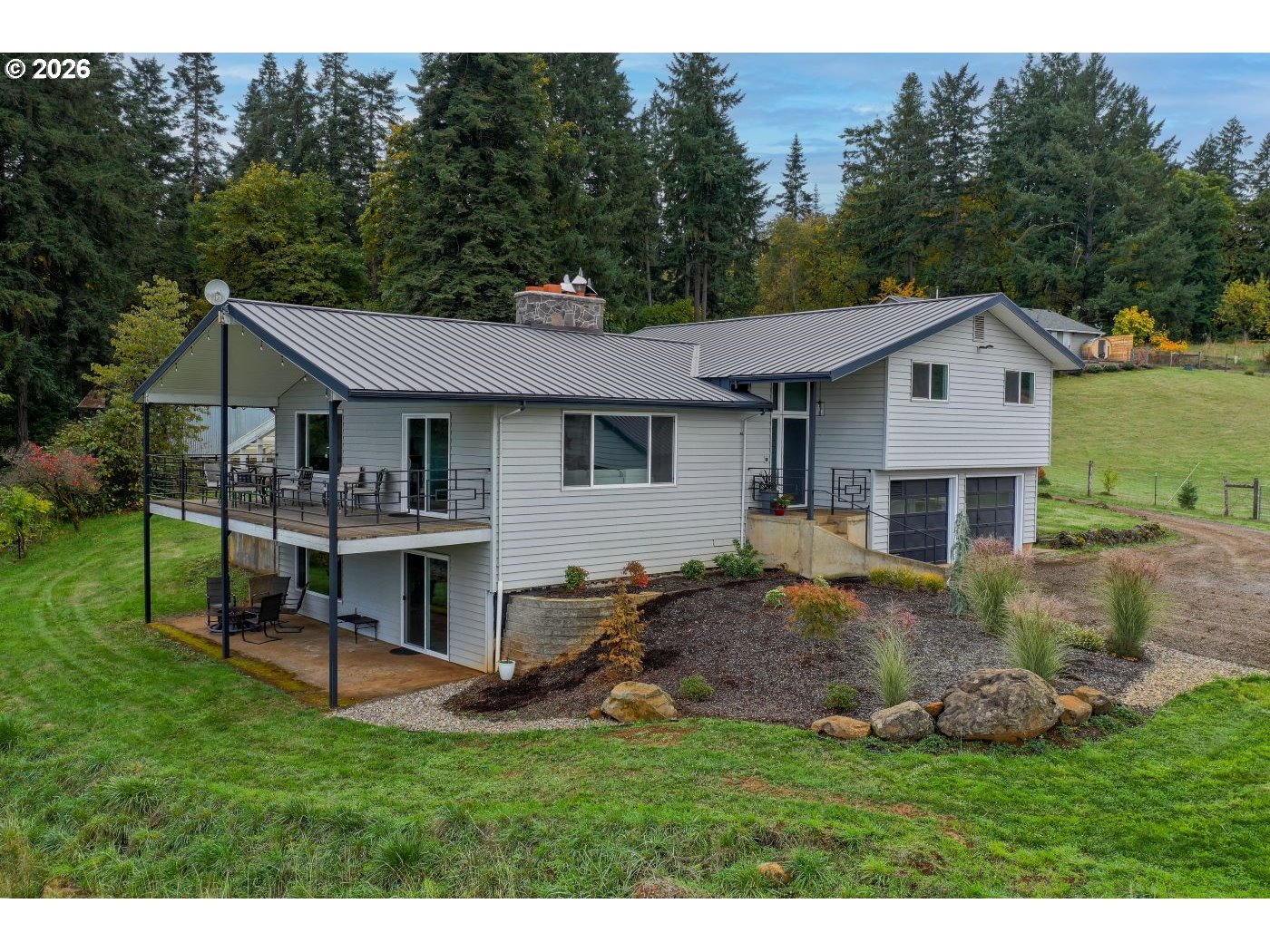 10854 Summit Loop Road Southeast Turner, OR 97392 - Photo 1 of 35 a front view of a house with a garden and trees
