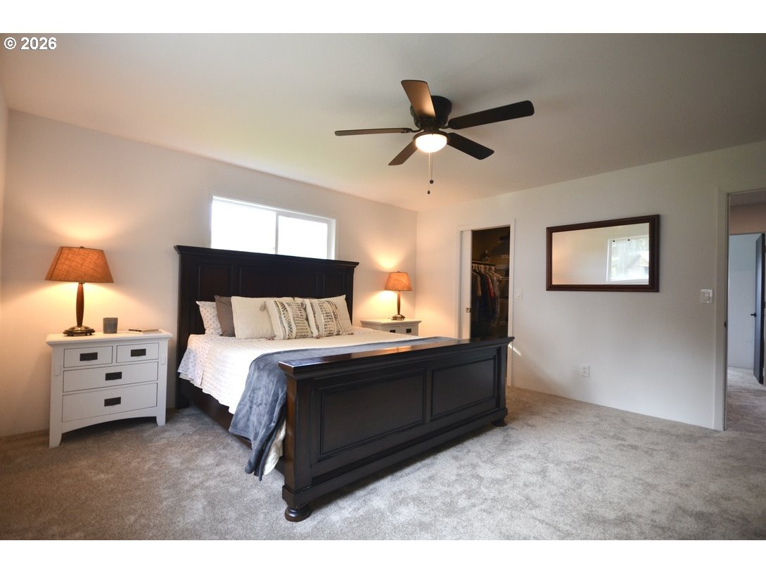 10854 Summit Loop Road Southeast Turner, OR 97392 - Photo 14 of 35 a spacious bedroom with a bed and a chandelier